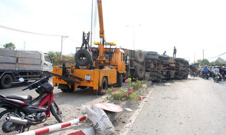 Đâm dải phải phân cách, xe tải chở gỗ lật nhào giữa quốc lộ